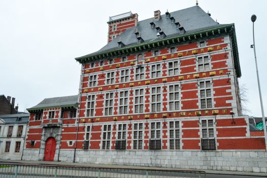 Red brick and gray stone building with golden ornaments