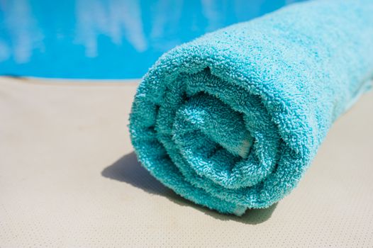 turquoise towel lies on the edge of the pool.