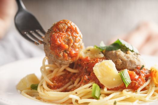 Woman eating spaghetti with meatballs horizontal close up