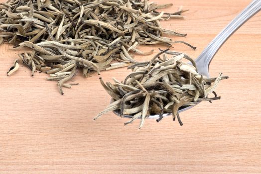 White needle tea on wooden cutting board