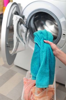 woman loading color clothes from washing machine