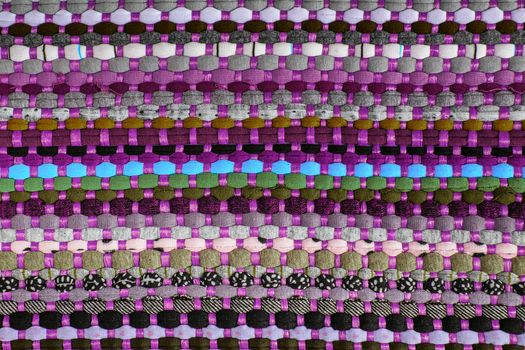 background, texture of colored handmade carpet. Fabric rug of small patches