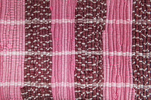 background, texture of colored handmade carpet. Fabric rug of small patches