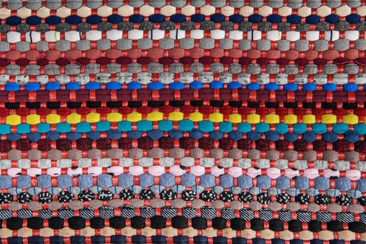 background, texture of colored handmade carpet. Fabric rug of small patches