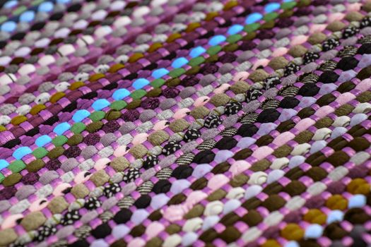 background, texture of colored handmade carpet. Fabric rug of small patches