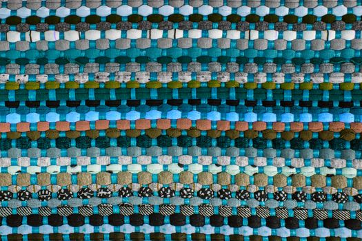 background, texture of colored handmade carpet. Fabric rug of small patches