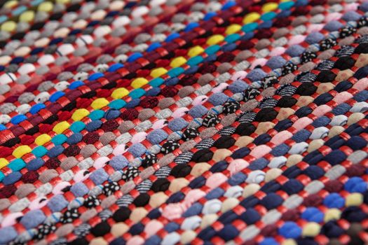 background, texture of colored handmade carpet. Fabric rug of small patches