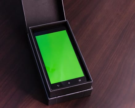 Smart phone with green screen on display in box