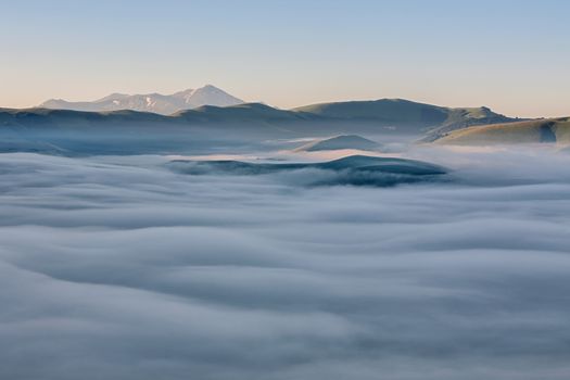 A thick fog covers the valley below in the morning at sunrise