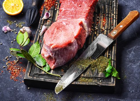 Raw veal meat on kitchen board with spice
