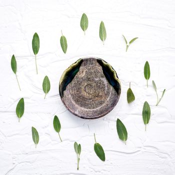 Closeup  fresh sage leaves with aromatic oil on white wooden background . Alternative medicine fresh salvia officinalis with flat lay.