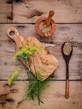 Close up blossoming branch of fennel and dried fennel seeds on rustic wooden background with flat lay.