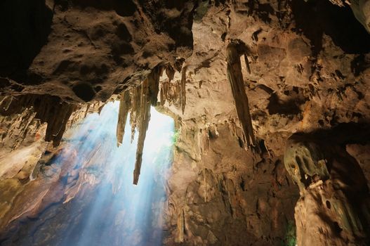 Sun rays in cave and beautiful stalactites formation in Thailand.           