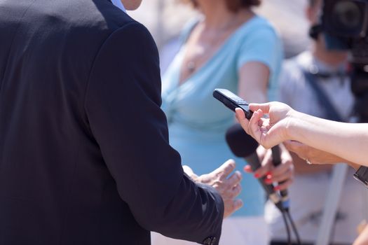 Reporters making interview with businessperson or politician. Press conference.