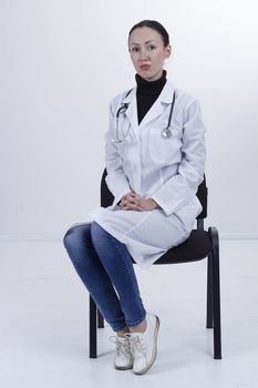 Serious female medical student sitting on chair