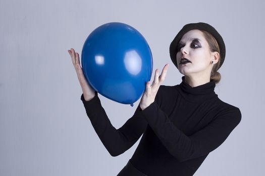 Young woman mime with blue ball