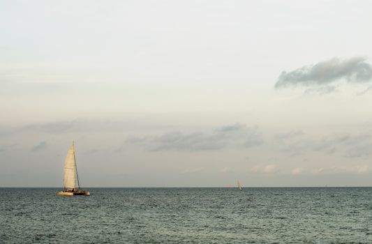 Lonely Sailboat on Mediterranean Sea Horizon in Summer Evening on Cloudy Sky background Outdoors