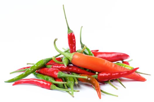 Heap of Perfect Red, Orange and Green Hot Chili Peppers closeup on White background