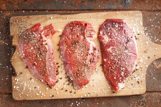Raw beef steak and spicel on cutting board top view horizontal