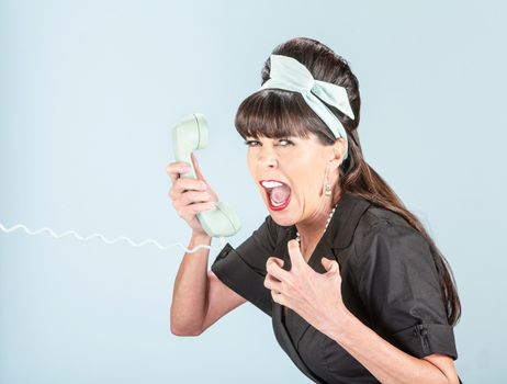 Close up on screaming woman in black dress with vintage phone receiver