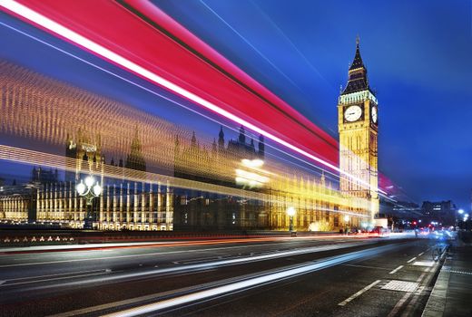 Big Ben, one of the most prominent symbols of both London and England, as shown at night along with the lights of the cars passing 