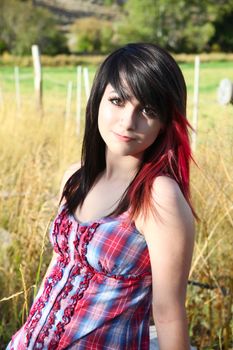 Beautiful brunette girl sitting outside with farmland in background