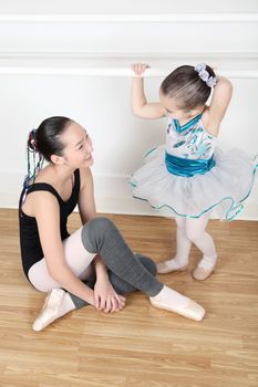 Teen dancer and toddler in costume at dance studio