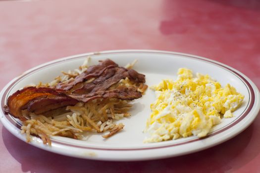 Breakfast plate of bacon, eggs and hashbrowns