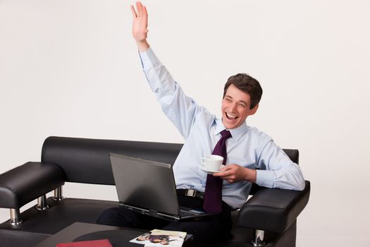 Young businessman working at the computer on isolated background