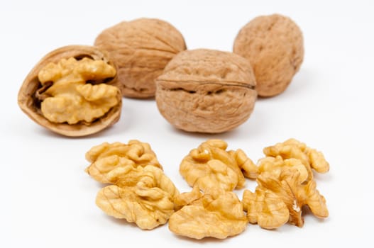 Whole walnuts and walnut kernels on white background