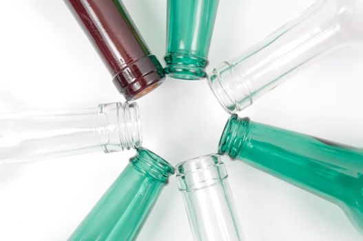 Empty glass bottles of mixed colors including green, clear white, brown