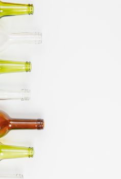 Empty glass bottles of mixed colors including green, clear white, brown