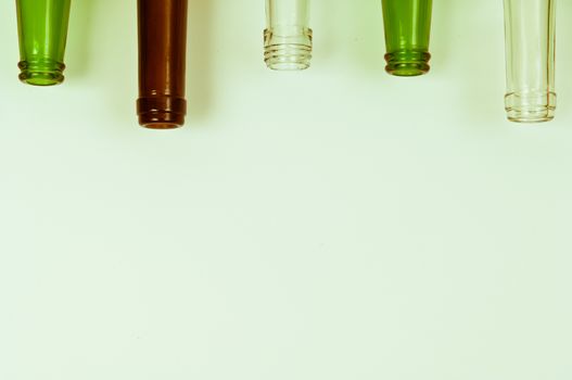 Empty glass bottles of mixed colors including green, clear white, brown