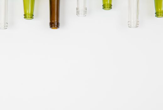 Empty glass bottles of mixed colors including green, clear white, brown