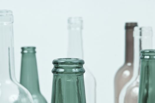 Empty glass bottles of mixed colors including green, clear white, brown