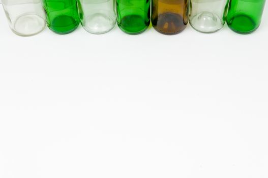 Empty glass bottles of mixed colors including green, clear white, brown