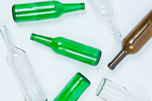 Empty glass bottles of mixed colors including green, clear white, brown