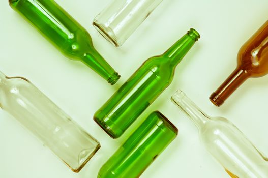 Empty glass bottles of mixed colors including green, clear white, brown