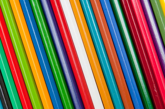 Pattern of color pencils isolated on black background close up