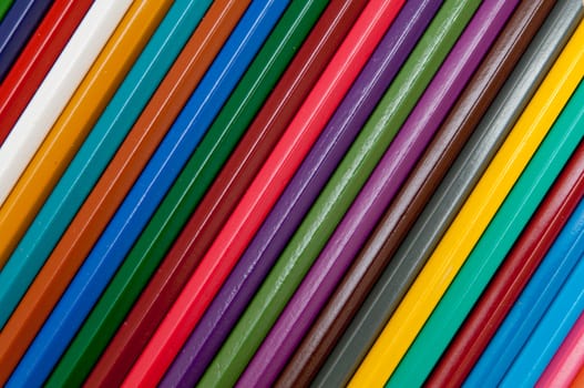 Pattern of color pencils isolated on black background close up