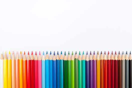 Pattern of color pencils isolated on white background close up