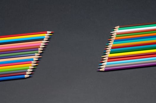 Pattern of color pencils isolated on black background close up