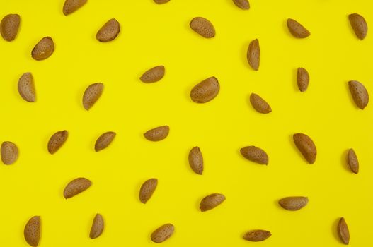 In shell raw almond on yellow background