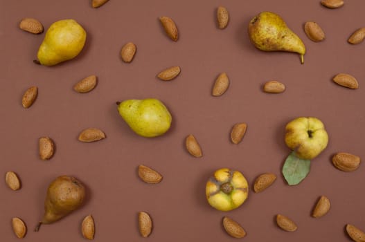 Autumn pear and nut pattern on brown background top view horizontal