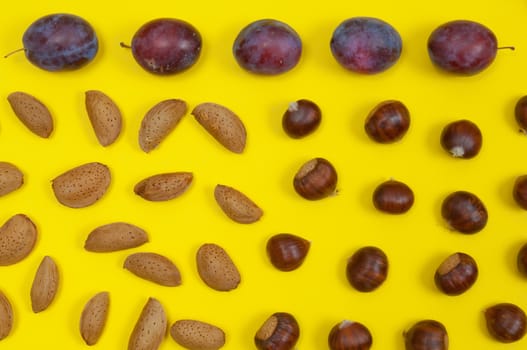 Autumn setting of organic  in shell nuts and fruits on yellow background