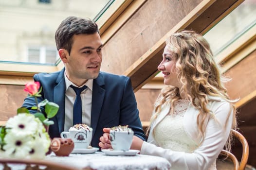 newly married couple drinking coffee in a cafe