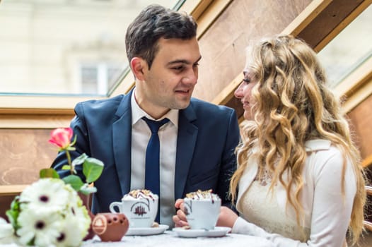 newly married couple drinking coffee in a cafe