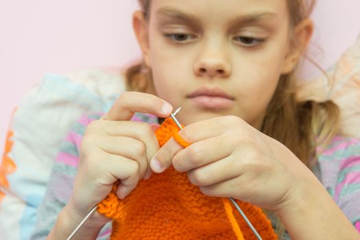 knits on the needles orange scarf, focusing on spokes