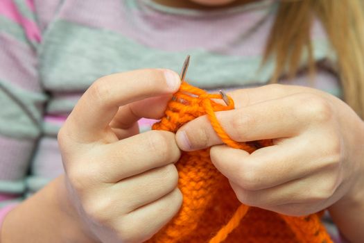 Close-up of children hands to knit with needles