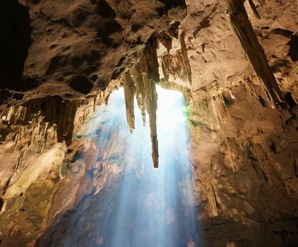 Sun rays in cave and beautiful stalactites formation in Thailand.           